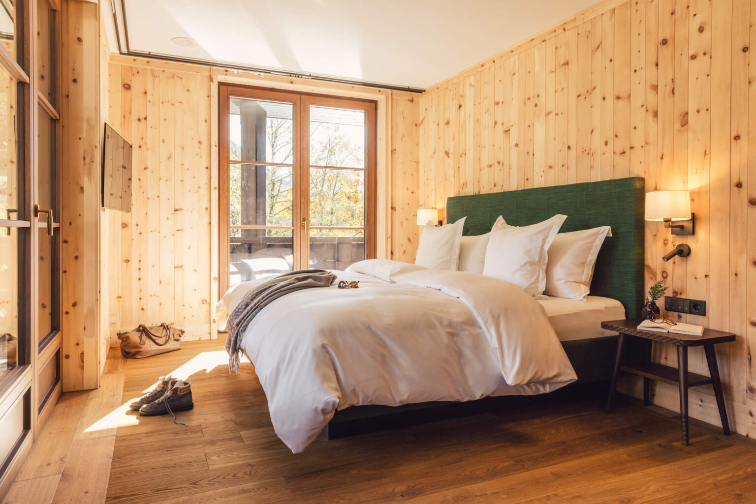 Großzügiges Doppelbett neben der Balkontür im Alpgues Zirbenzimmer.