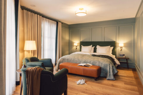 Blick auf das Doppelbett in einem Zimmer der Kategorie "Taube Classic Family" im Posthotel Taube.