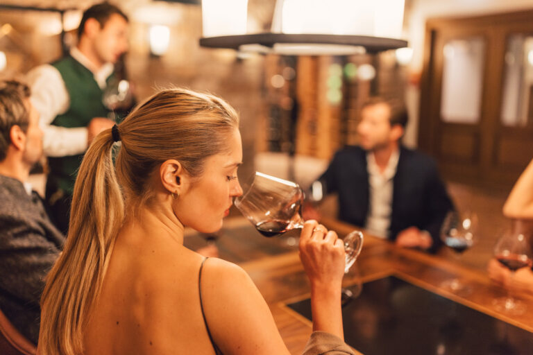 Besucherin genießt Rotwein im Posthotel Taube in Schruns