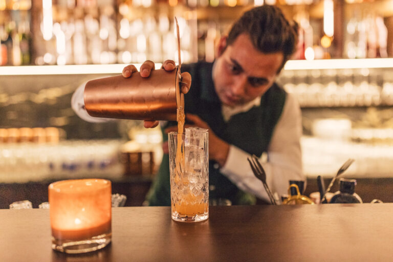 Barkeeper bereitet Cocktail vor im Posthotel Taube in Schruns